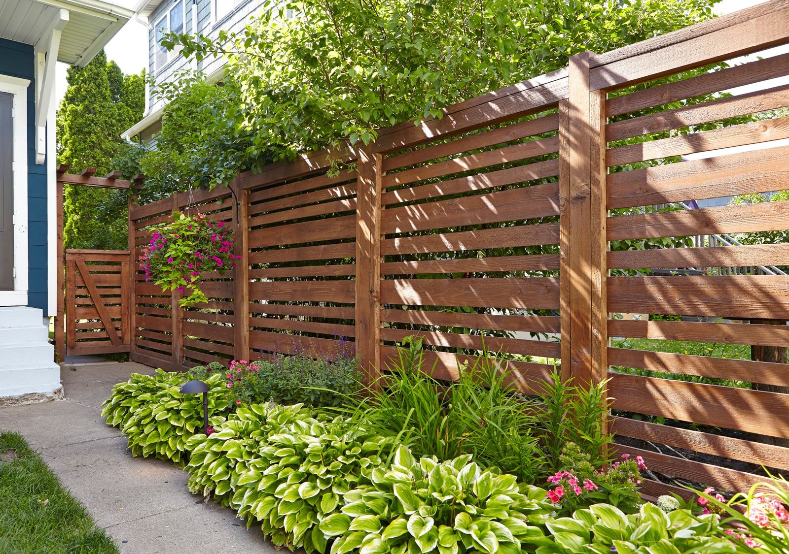 A custom-designed wooden fence with intricate lattice work or decorative post caps, showcasing the fine carpentry of Runika.pro in Miami