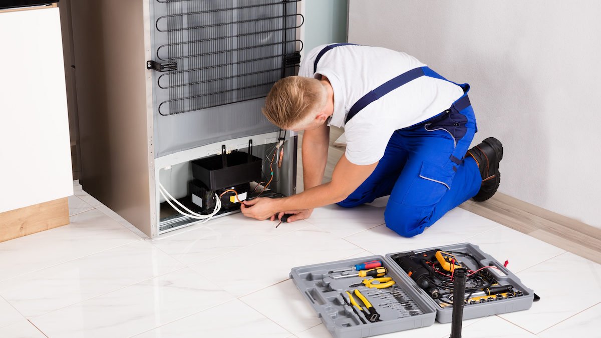 Expert Appliance Diagnosis & Repair Miami | Honest Service, Lasting Fix A certified Runika.pro expert using professional tools to diagnose a complex electrical issue in a dishwasher or oven in a Miami kitchen