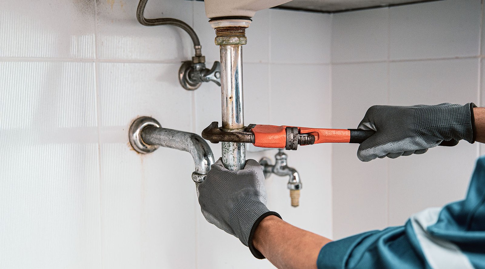 A uniformed and professional Runika.pro plumbing technician performing a careful repair on a residential plumbing fixture in Miami