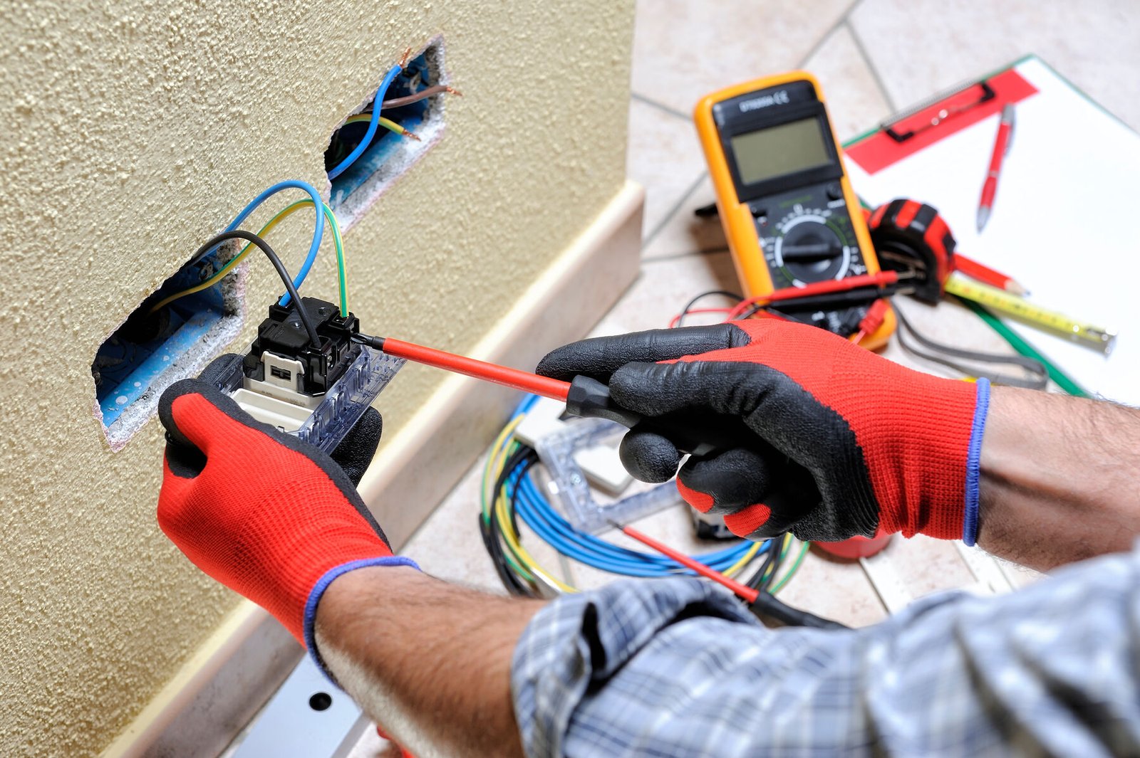 Small Electrical Repairs Miami | Fast, Trusted Electricians | Runika.pro A uniformed Runika.pro electrical technician fixing a non-working power outlet during a service call in a Miami home