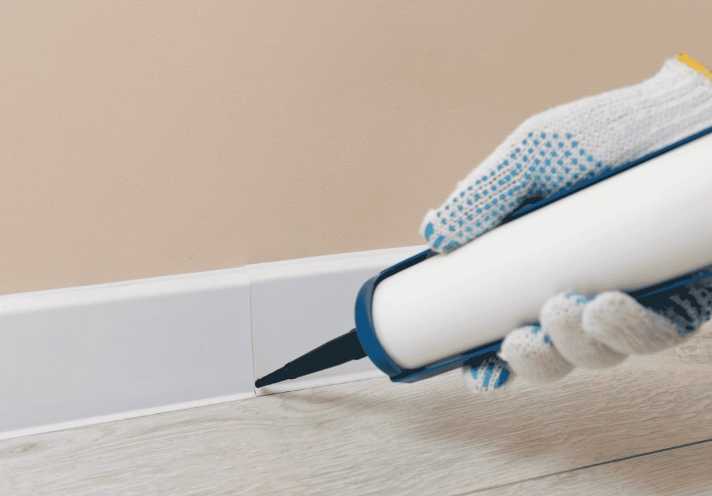 Runika.pro technician applying exterior-grade sealant to expansion joints, siding seams, or around outdoor fixtures on a Miami home