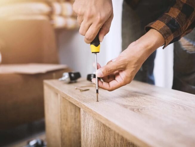 A Runika.pro technician in Miami expertly assembling a complex piece of furniture, such as a sectional sofa or a large wardrobe, with precision tools