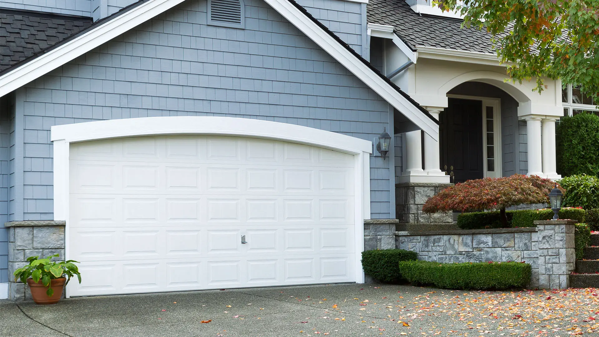 A stylish, modern custom garage door being precisely fitted and installed by Runika.pro craftsmen to enhance a Miami home's facade