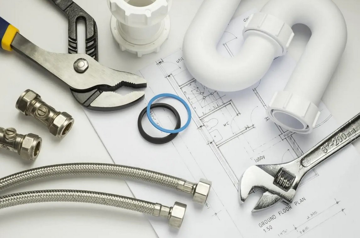 Plumbing blueprints, professional pipe wrenches, and a new faucet arranged neatly, representing the detailed planning and expert execution of Runika.pro's Miami plumbing services