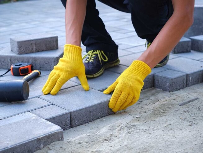 Skilled Runika.pro craftsman in Miami meticulously installing interlocking concrete pavers for a durable and level patio foundation