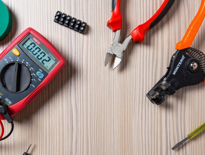 A complete set of professional electrical tools, including a voltage tester, wire strippers, and screwdrivers, organized and ready for Runika.pro's Miami service calls