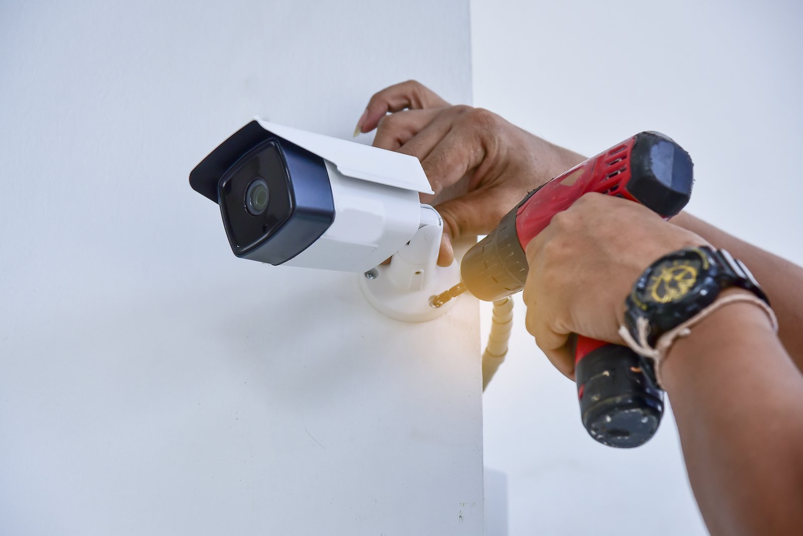 Professional Home Security Camera Installation Miami | Protect Your Property A Runika.pro security expert in Miami professionally mounting a high-definition security camera on the exterior of a house for optimal coverage